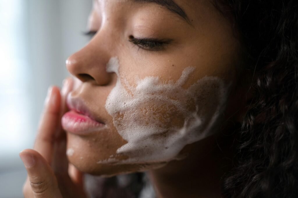 A woman double cleansing her face