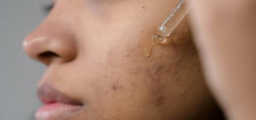 A woman applying a serum on her face