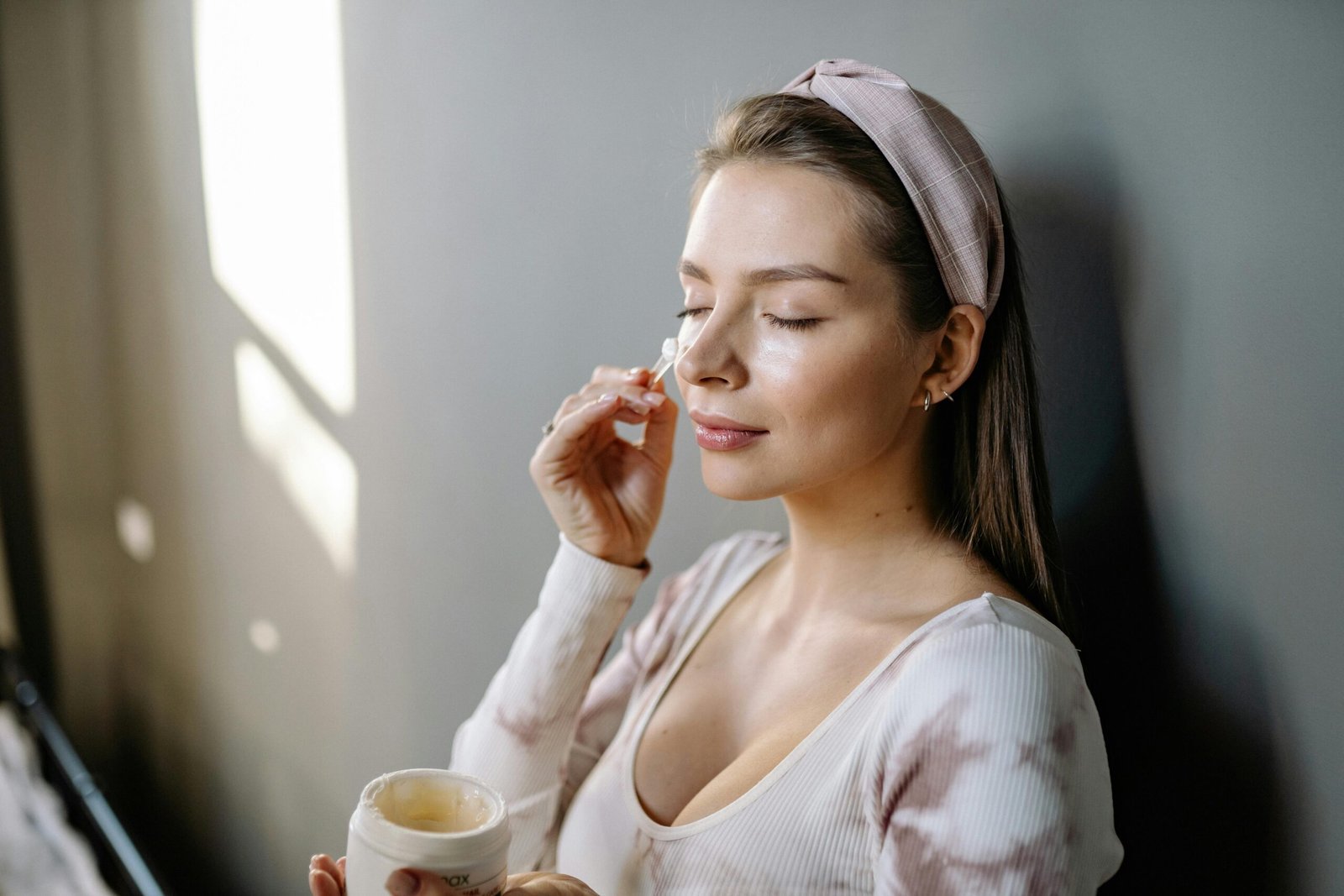 A woman applying eye cream for sensitive skin