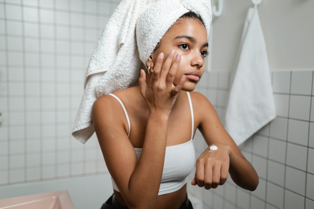 A woman applying moisturizer on her face