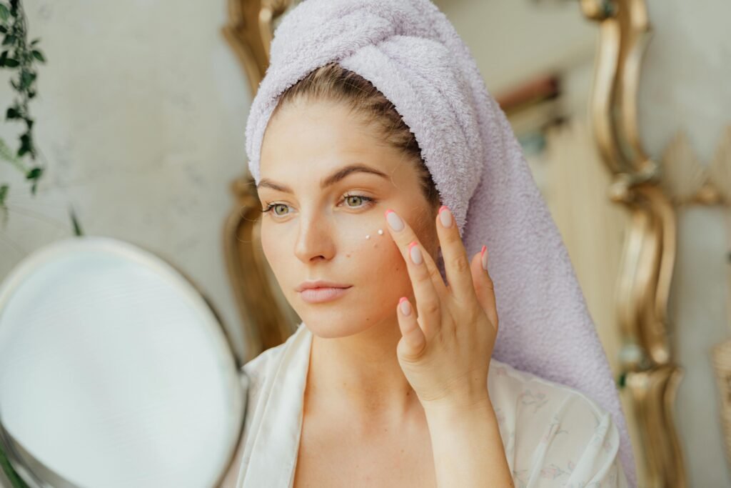 A woman putting cream on her face