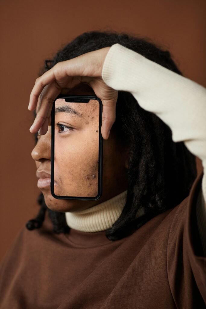 A woman holding a phone showing her face