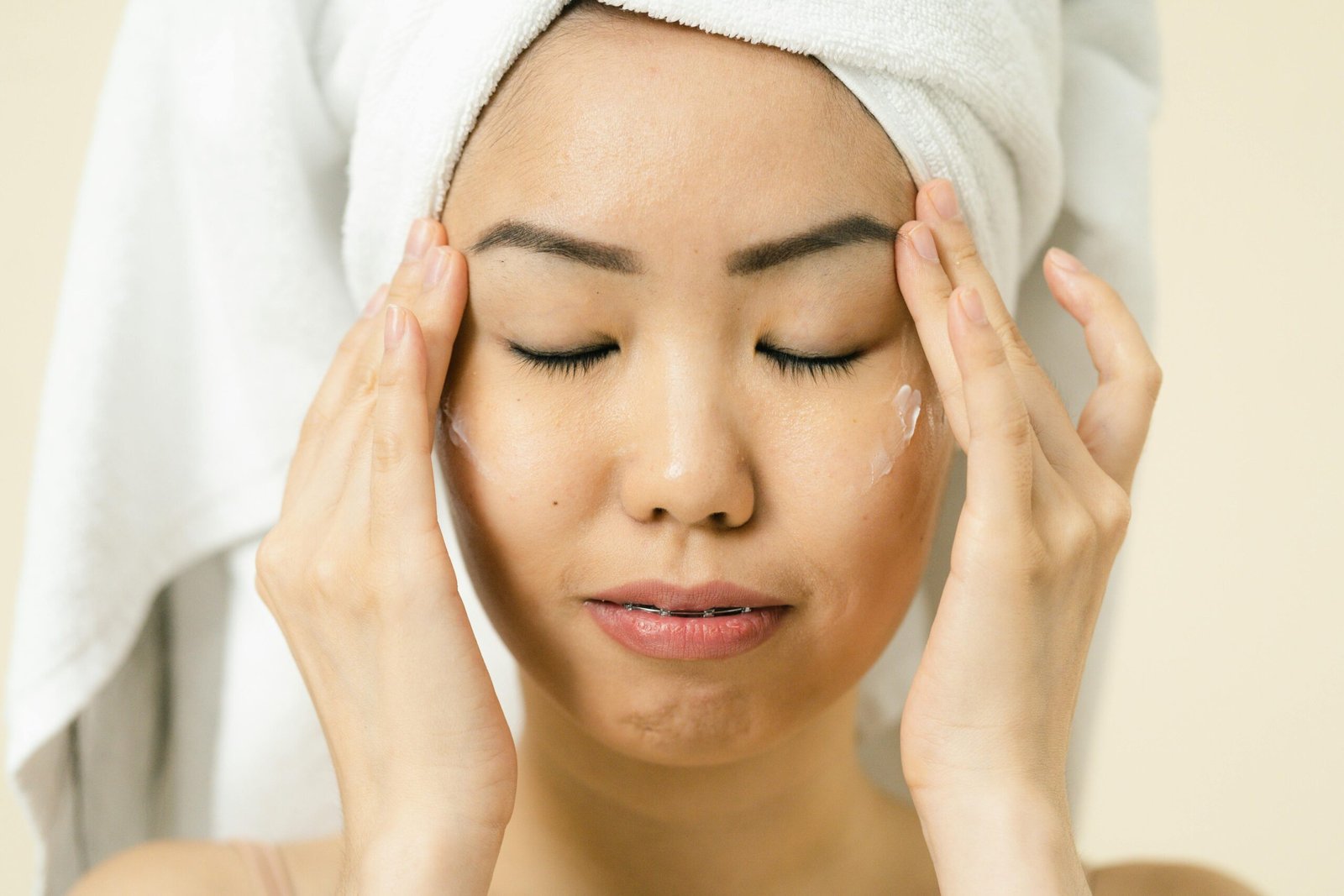 A woman using eye cream to brighten her under eye area