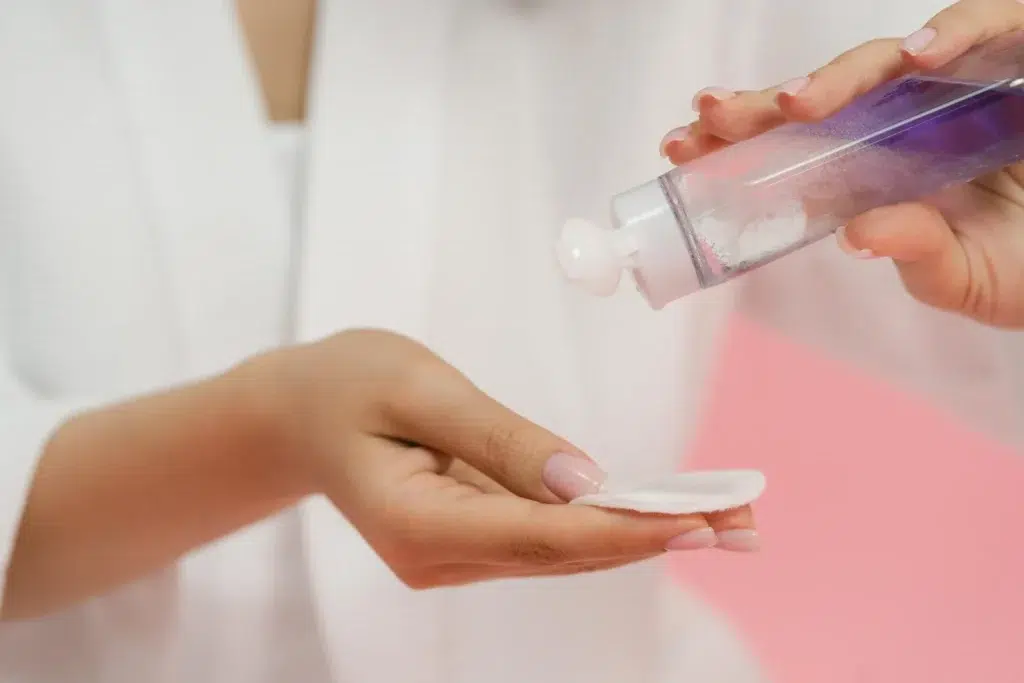 A person holding a toner for reducing redness and inflammation