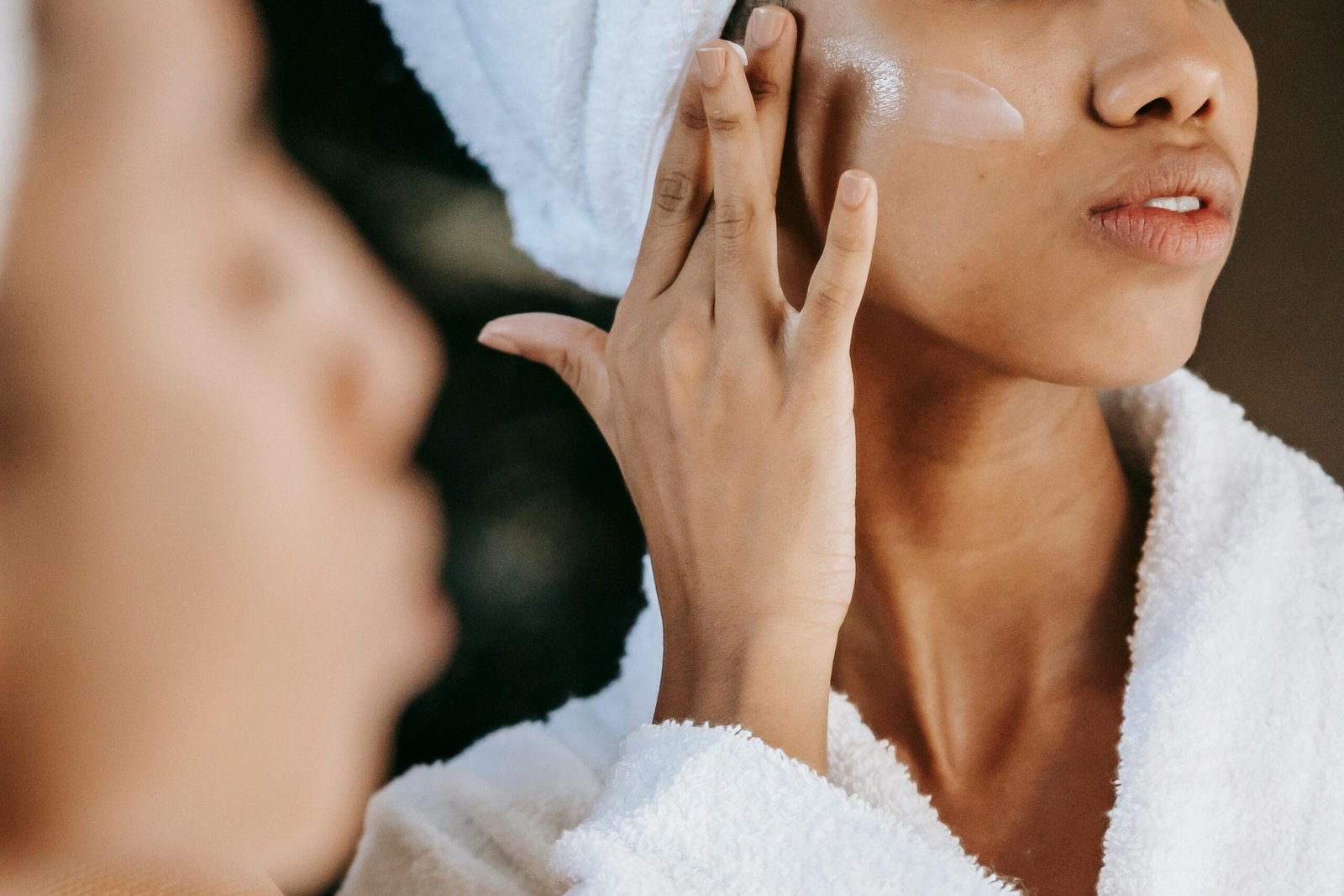 A woman applying moisturizer on her face